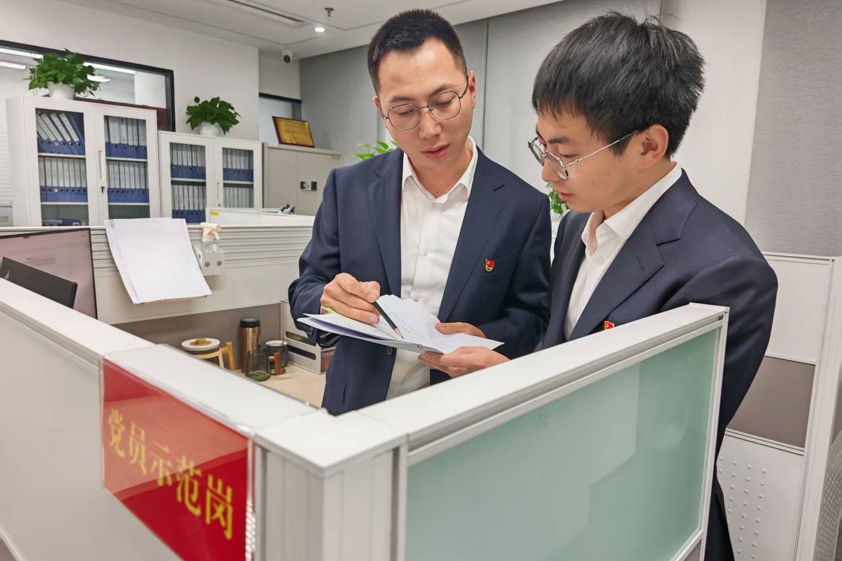 党员示范岗党员为同事讲解智慧结算业务 葛萌摄.jpg 金贝官网